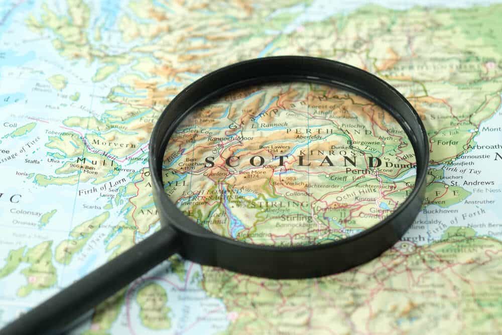 A magnifying glass rested over a map showing Scotland