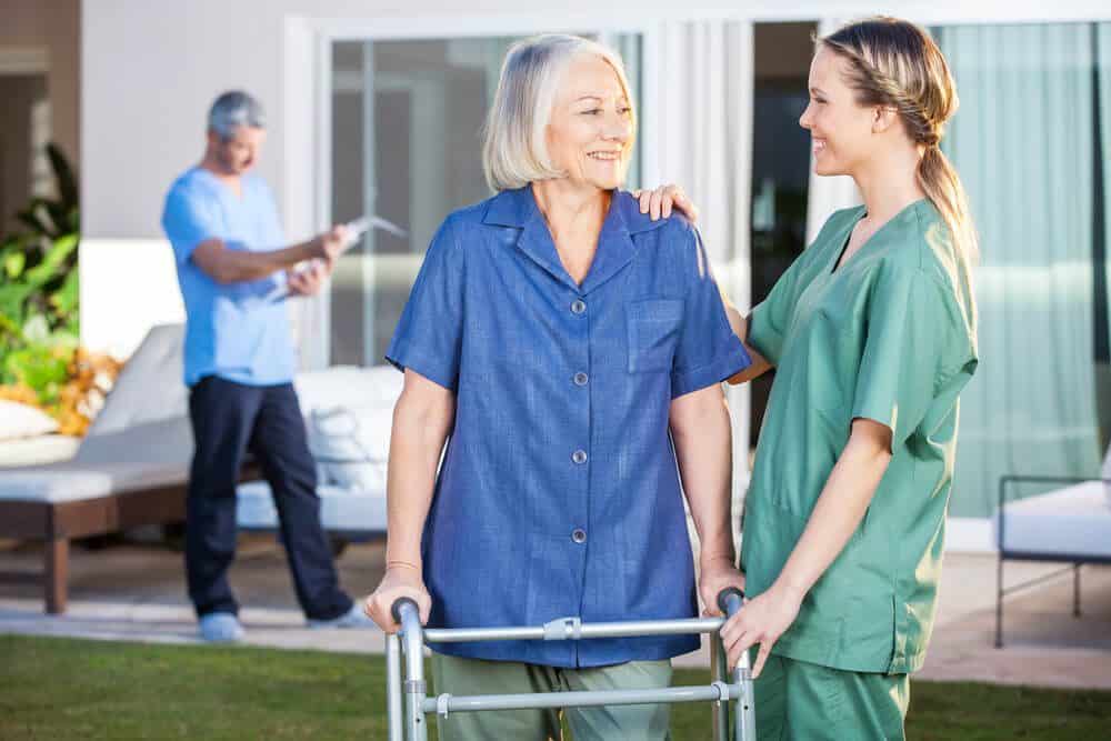 A nurse talking with an elderly lady in her garden