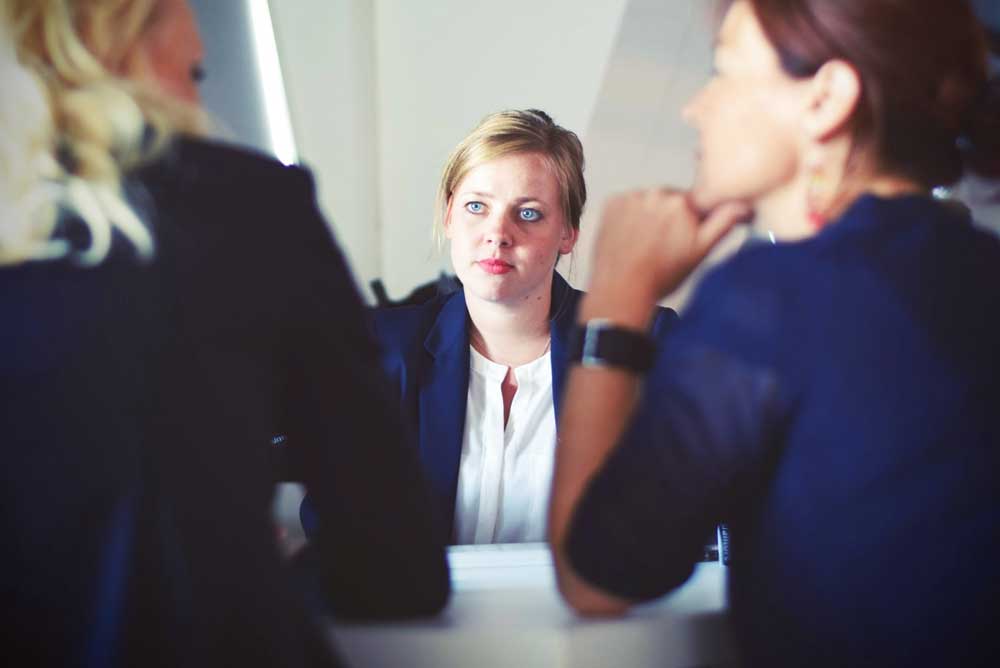 Three businesswomen sat down and talking around a table